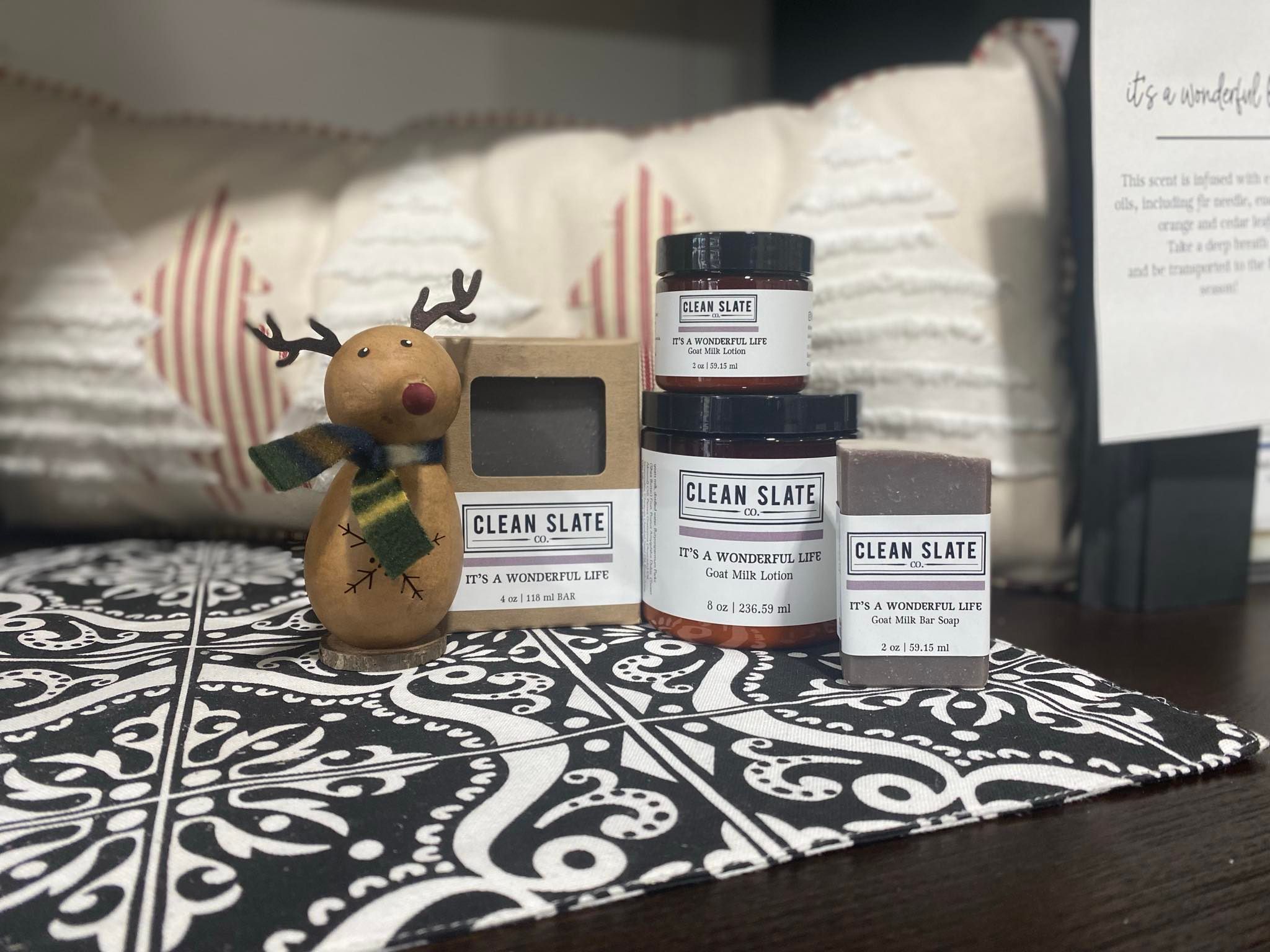 Display of soap and lotion with holiday decor surrounding the display.