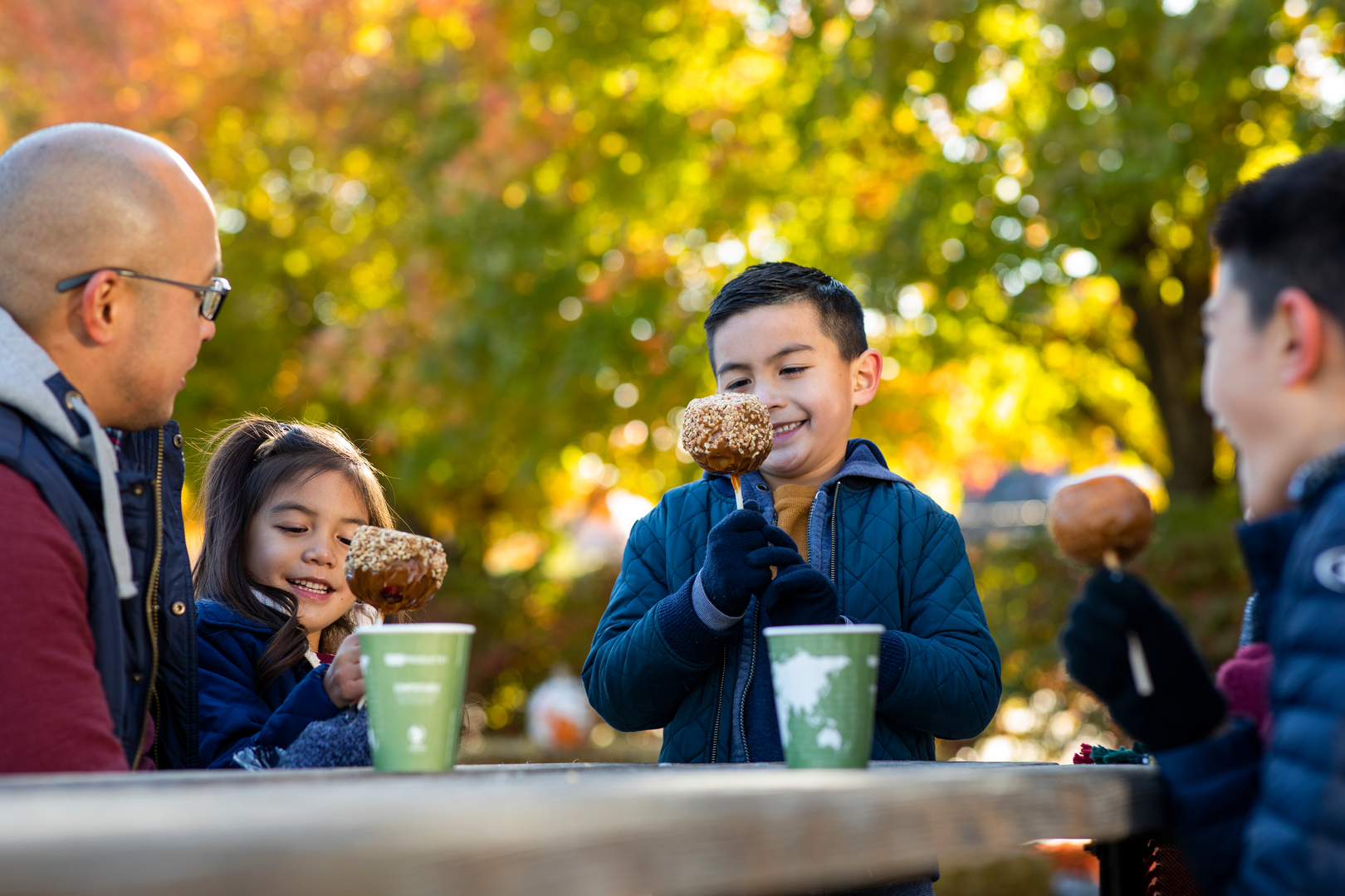 A family with children enjoying caramel apples at Arbor Day Farm in Nebraska City.