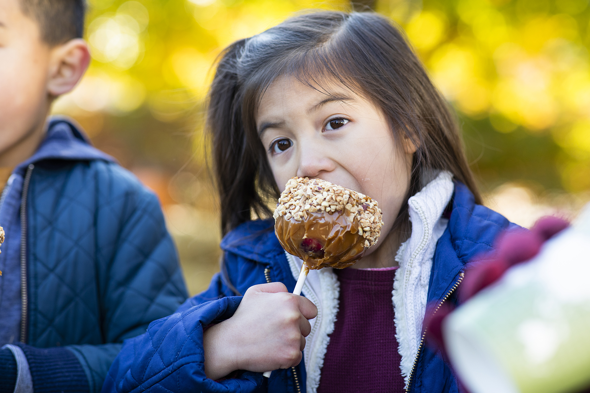 Child eating a caramel apple at Arbor Day Farm in Nebraska City. | Geoff Johnson