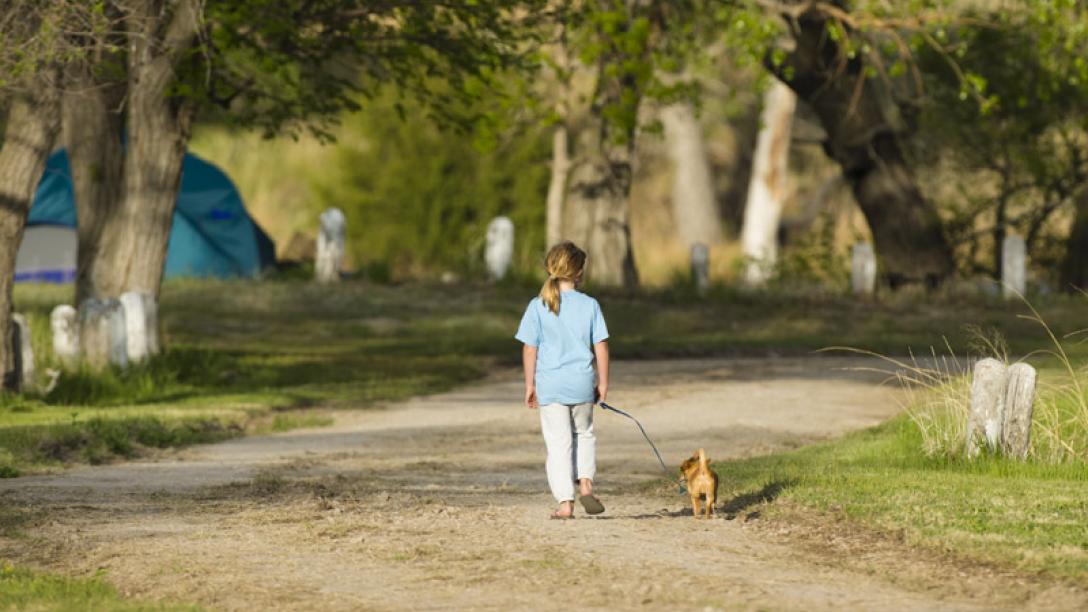 Girl walking dog in state park