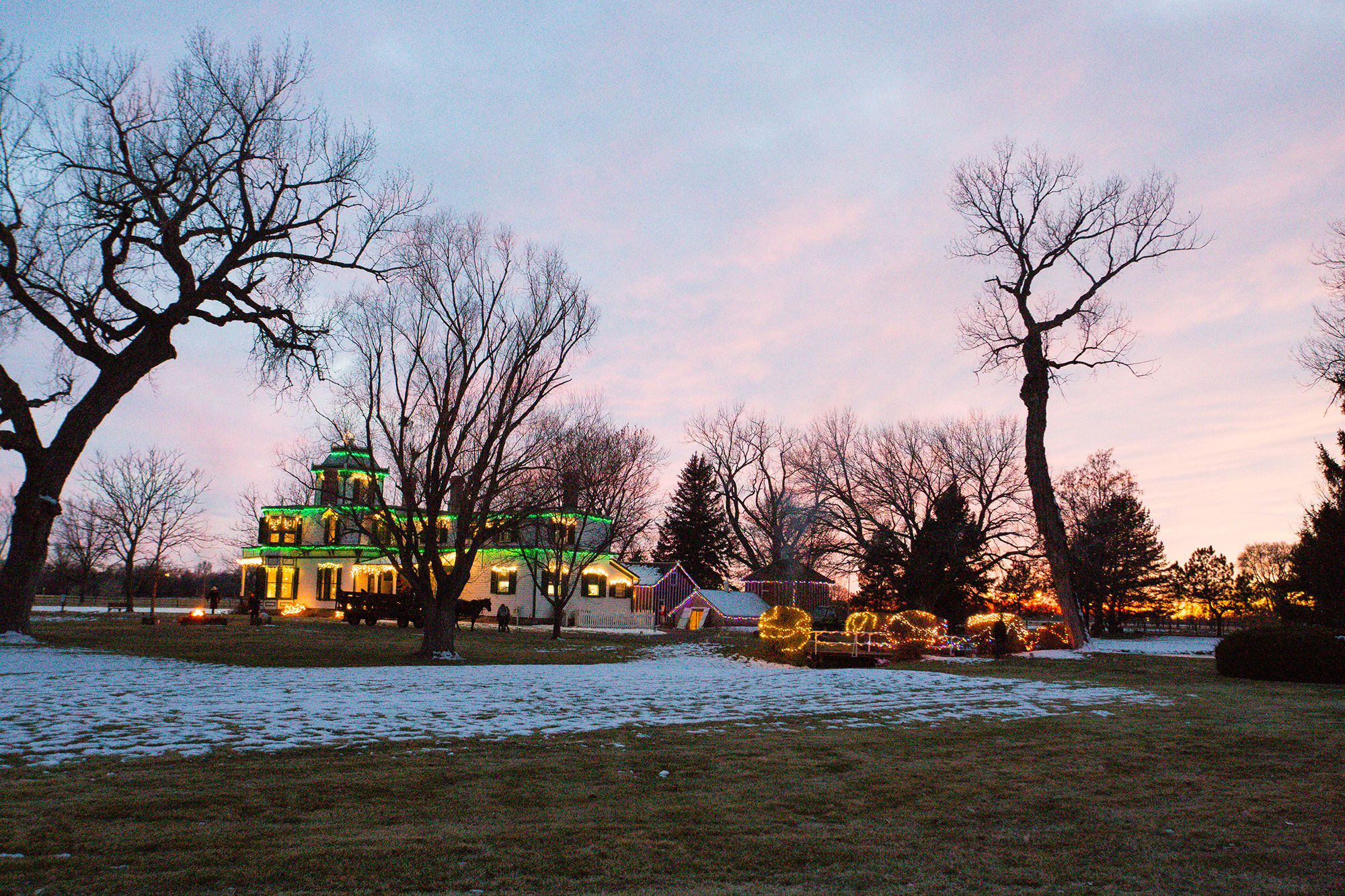 Buffalo Bill's mansion decorated in Christmas lights at dusk. 