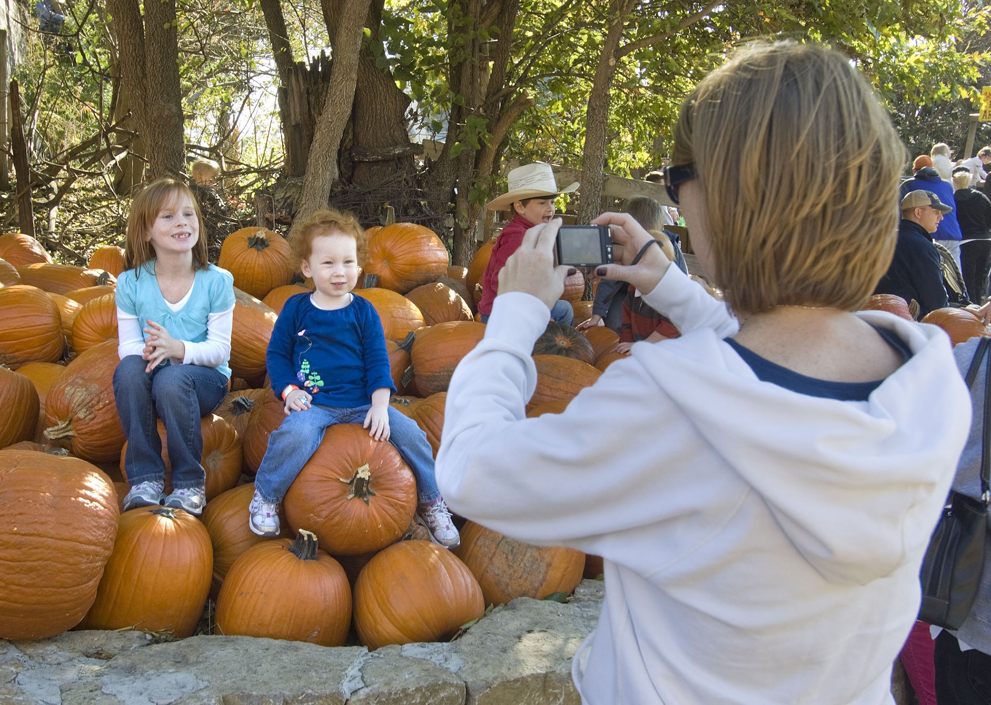 Kids posing on a pile of pumkins at Vala's Pumpkin Patch.