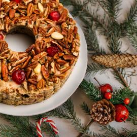 A coffee cake on display with holiday decorations in the background.