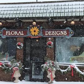 Store front of Floral Designs with a snow falling.