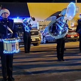 Band playing music with Christmas lights decorating their instruments.