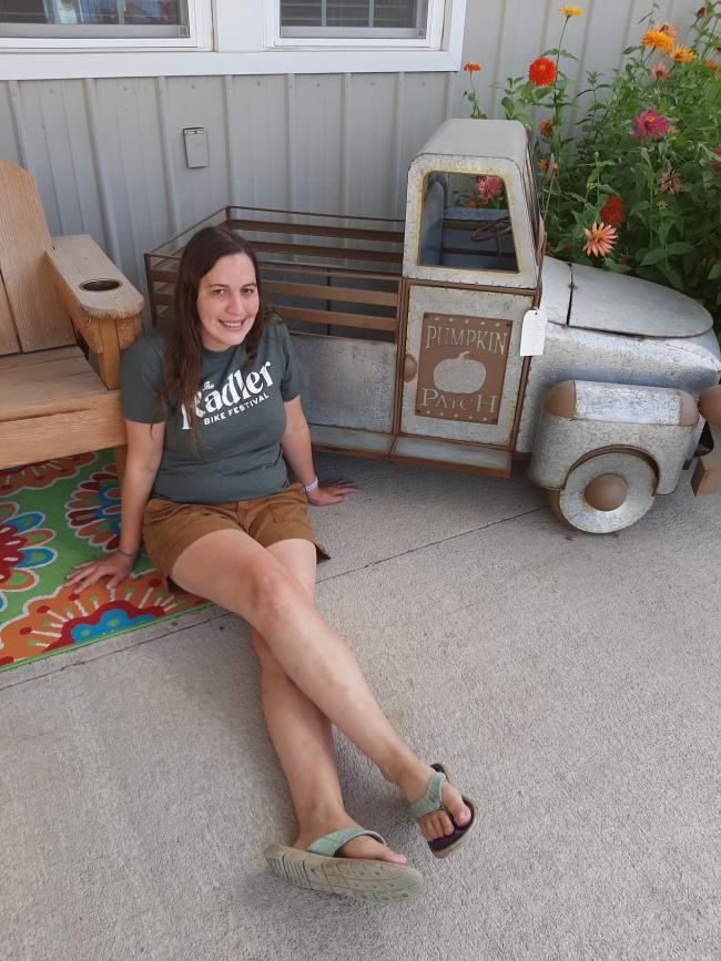 Girl sitting by antique truck display